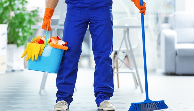 a man holding a bucket with cleaning equipment