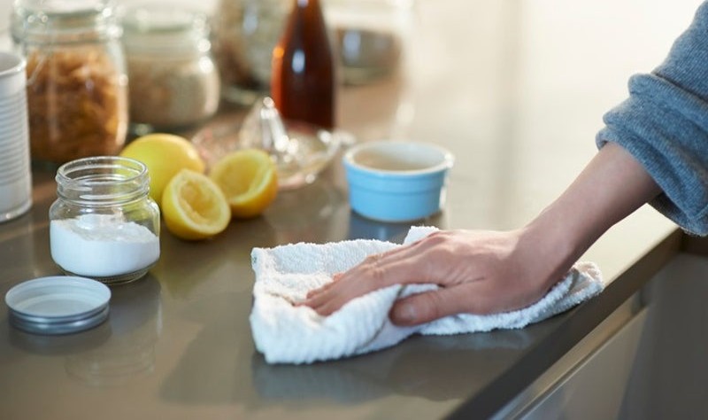 cropped picture of a person wiping a surface using natural products