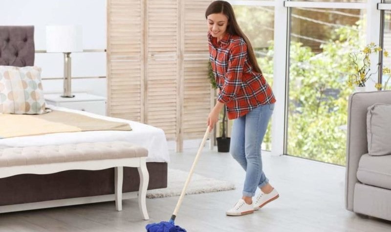 young woman wiping the floor with a mop