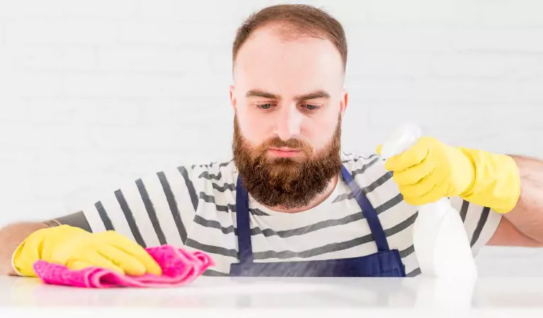 young man cleaning a surface with a cleaner