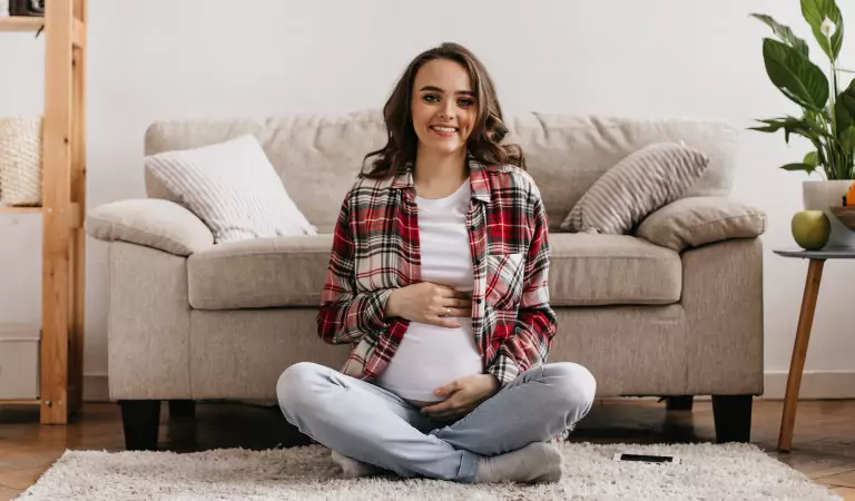 pregnant woman sitting on a carpet