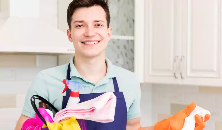 young man with some cleaning products looking ready to clean