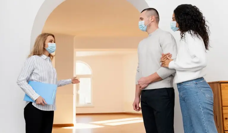 Landlord is talking with a couple inside a living room
