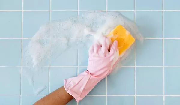 person cleaning tiles