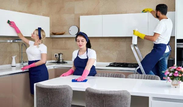 Cleaning service team at work in kitchen in private home