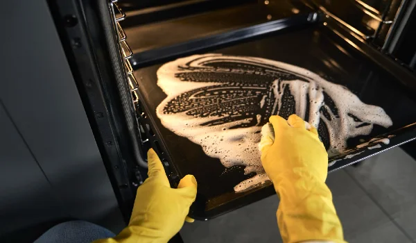 Close up of caucasian woman cleaning oven at home