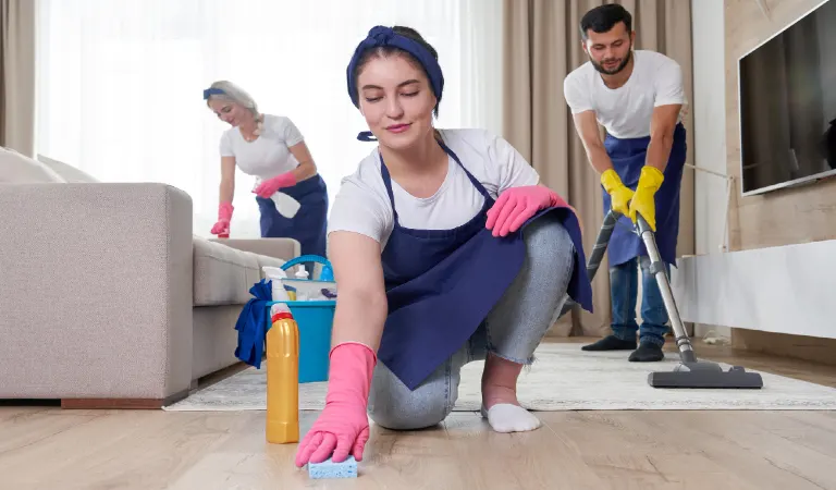 Professional cleaning service team cleans living room in modern apartment