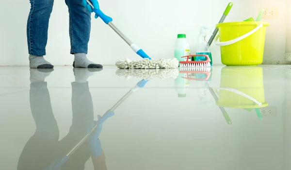 Low section of person cleaning while standing on floor