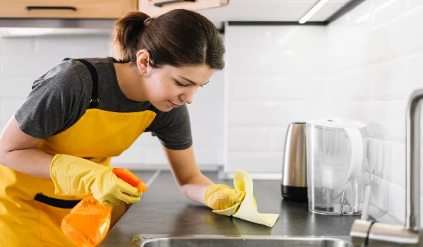 Medium shot woman cleaning kitchen