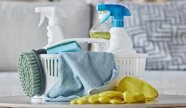 Cleaning products brush and basket on table in home living room for housekeeping hygiene spring cleaning and cleaning supplies